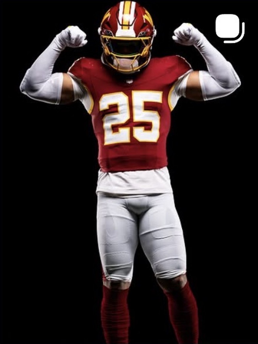 Nick Cross flexing in the burgundy Commanders number 25 uniform