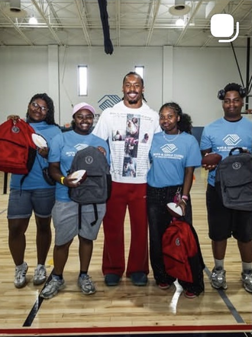 Nick Cross handing out backpacks with Boys and Girls Clubs members