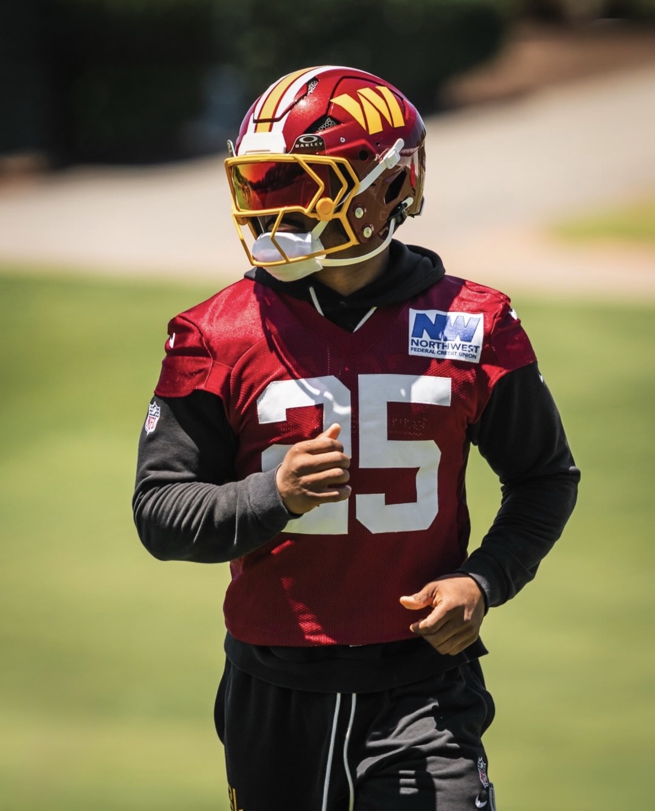 Nick Cross jogging on the field in his burgundy Commanders helmet and red-visor face mask