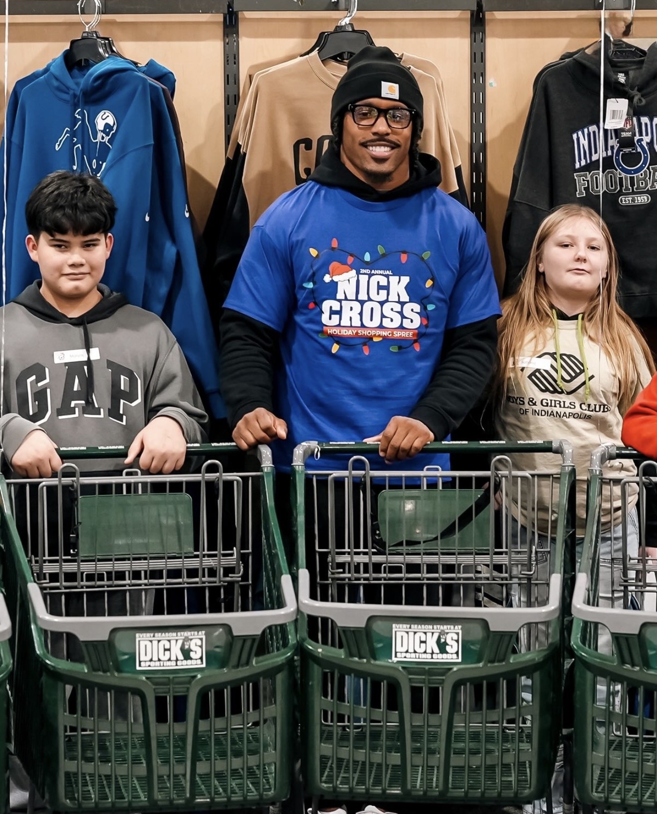 Nick Cross in his Holiday Shopping Spree shirt with kids and shopping carts at the store