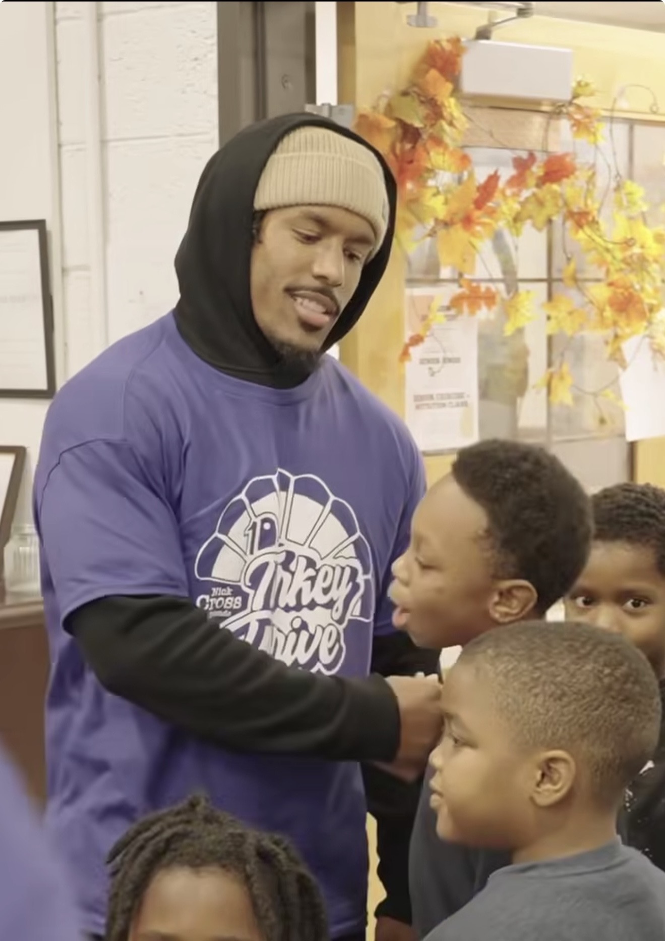 Nick Cross in his Turkey Drive shirt talking with a group of young boys at the event